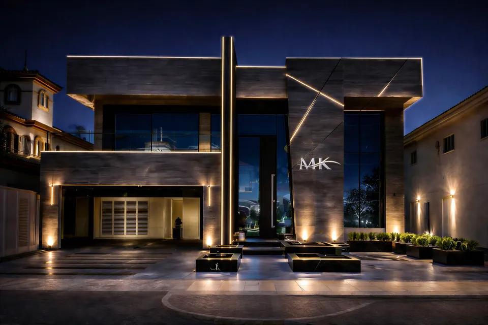 MK Villa، نخلة جميرا: واجهة فيلا عصرية ليلاً بجدران مكسوة بألواح رمادية، وخطوط عمودية مضاءة، وحروف MK.