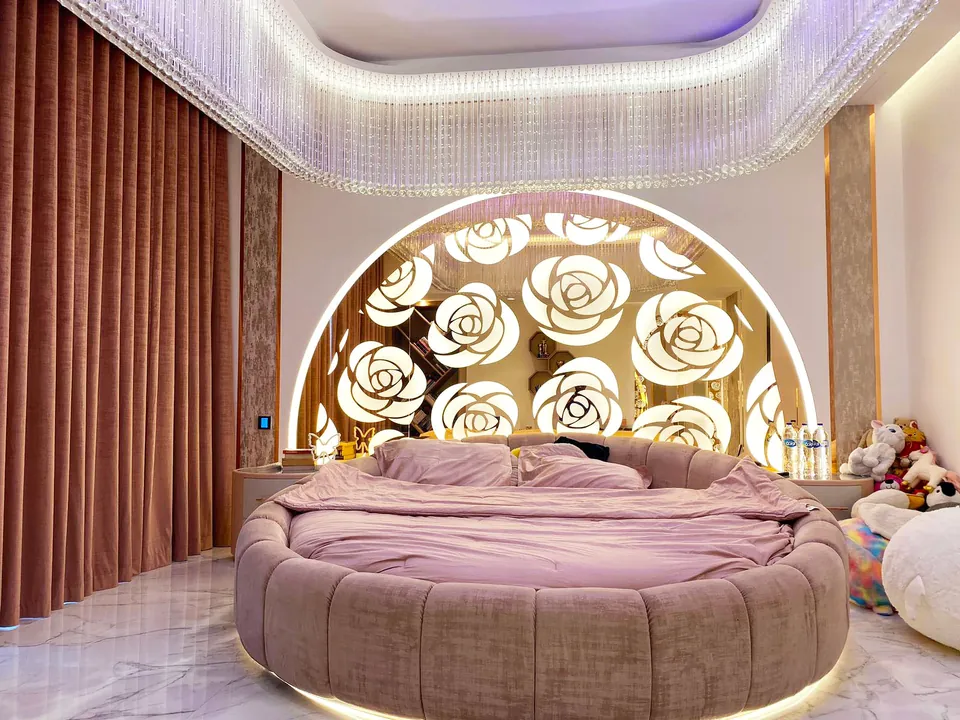 MK Villa, Palm Jumeirah: round pink bed before a lit arch of rose motif panels, beneath a crystal ceiling surround.
